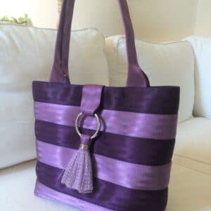 purse in two tones of purple sitting on couch