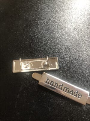 bagmaking hardware tag that says handmade