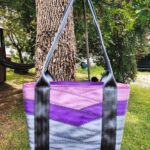 front view of purple and grey motor city seat belt tote on tree