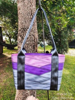 front view of purple and grey motor city seat belt tote on tree