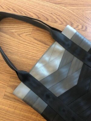 seat belt tote in shades of grey laying on floor