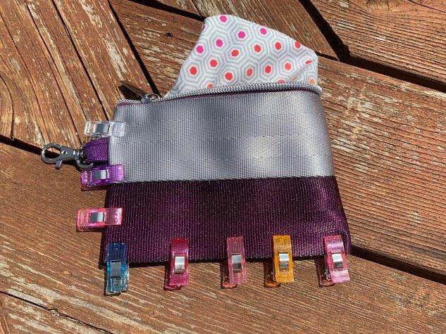 Pouch is turned right side out and and lining is show peeking out. Clips are around bottom and side edge with swivel clip