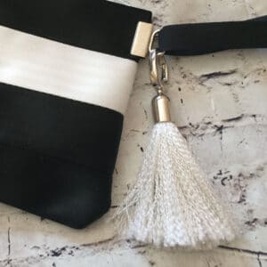 white tassel attached to black and white pouch