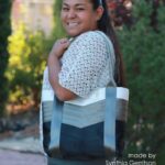 woman holding white grey and black seat belt tote