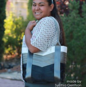 woman holding white grey and black seat belt tote